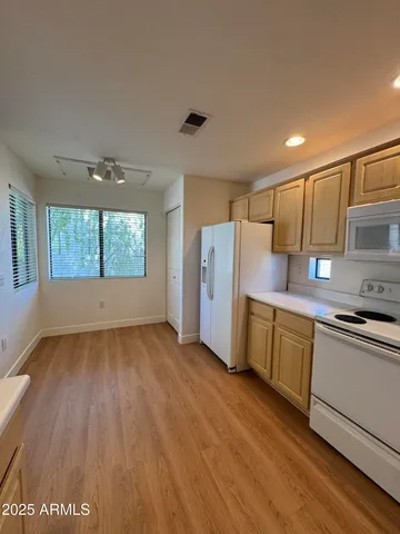 a kitchen with a wooden floor and a window