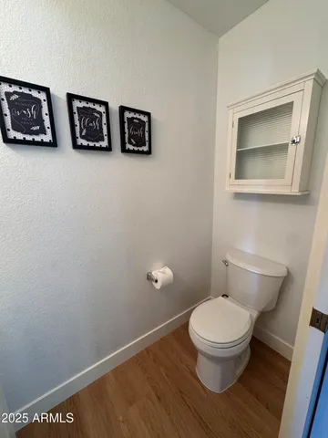 a white toilet sitting next to a white wall