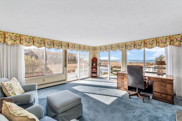 a living room with furniture a fireplace and large windows