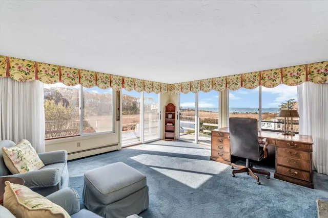 a living room with furniture a fireplace and large windows