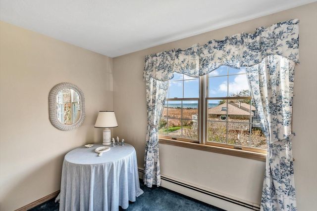 a bedroom with a bed window and a table in it