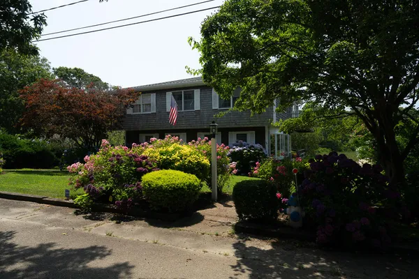 a front view of a house with a garden and plants