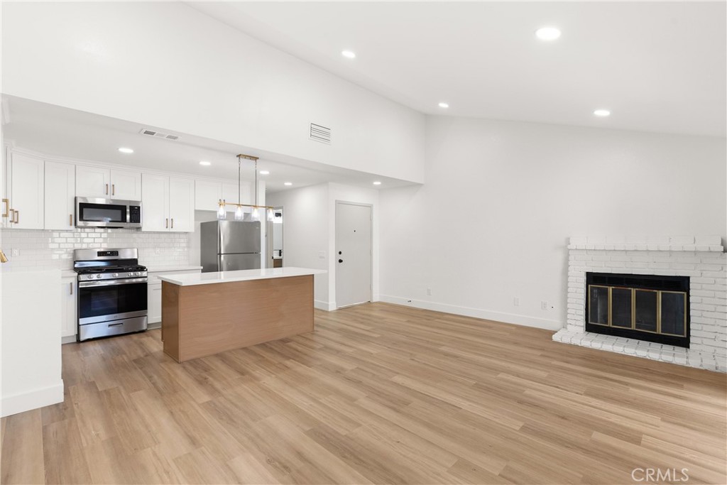 a kitchen with stainless steel appliances kitchen island wooden cabinets and granite counter tops