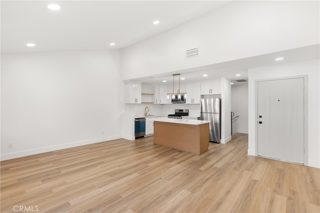 87 Tennessee Street, Unit C Redlands, CA 92373 - Photo 14 of 32 a large kitchen with kitchen island a sink stainless steel appliances and cabinets