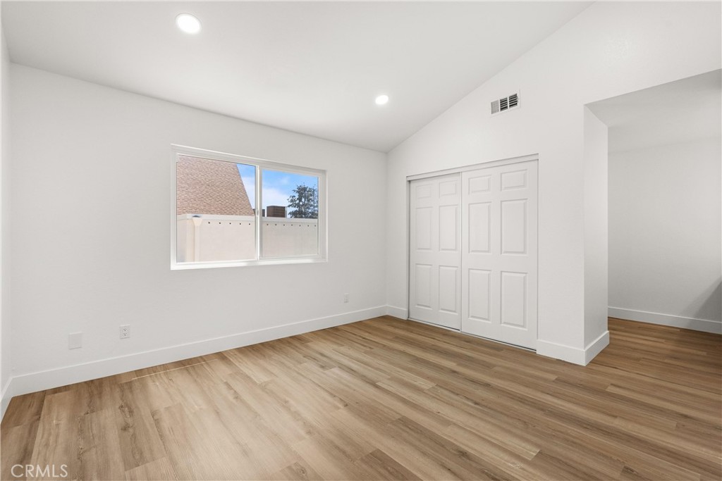 87 Tennessee Street, Unit C Redlands, CA 92373 - Photo 16 of 32 an empty room with wooden floor and windows
