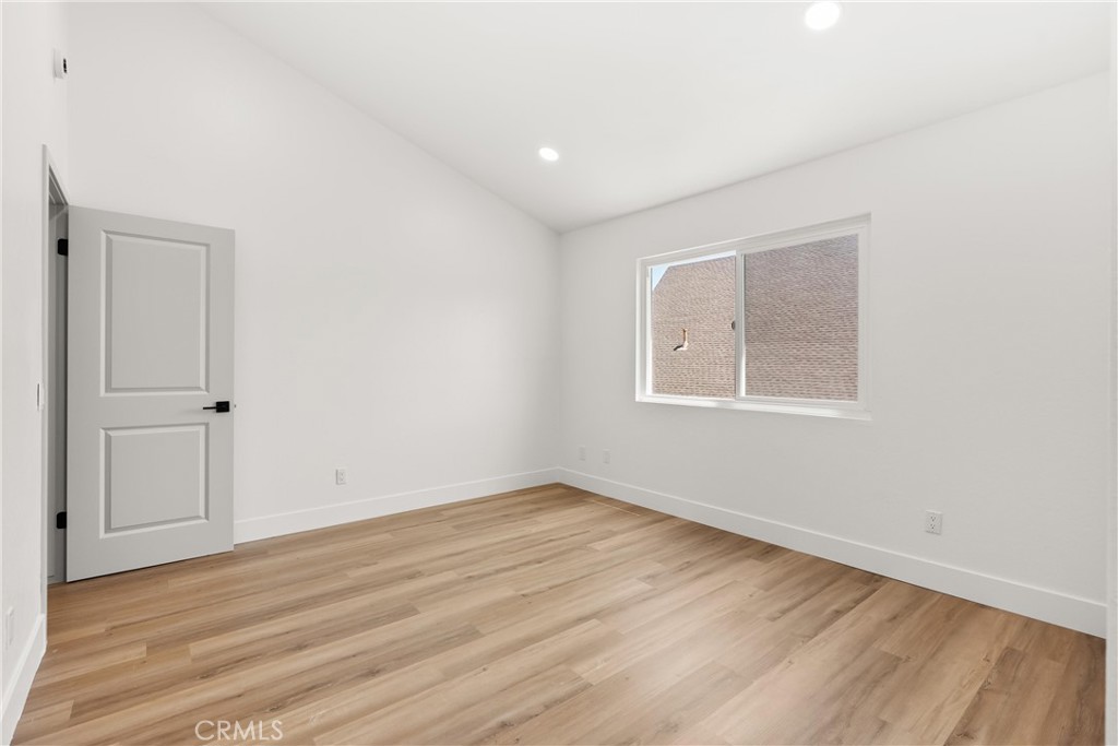 87 Tennessee Street, Unit C Redlands, CA 92373 - Photo 18 of 32 an empty room with wooden floor and windows