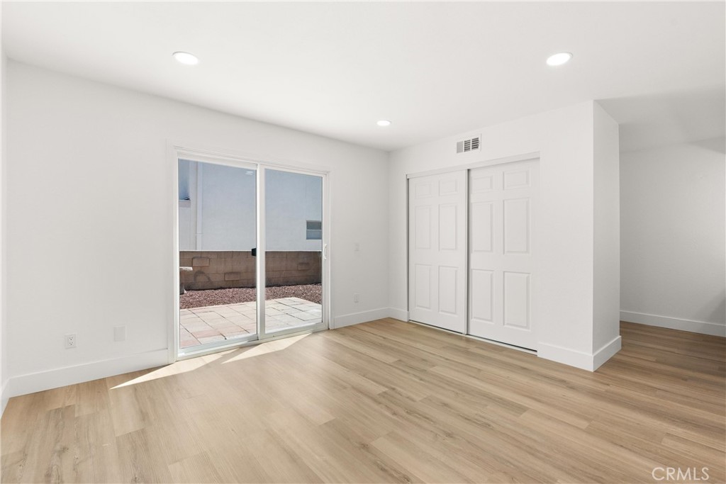 87 Tennessee Street, Unit C Redlands, CA 92373 - Photo 23 of 32 an empty room with wooden floor and windows