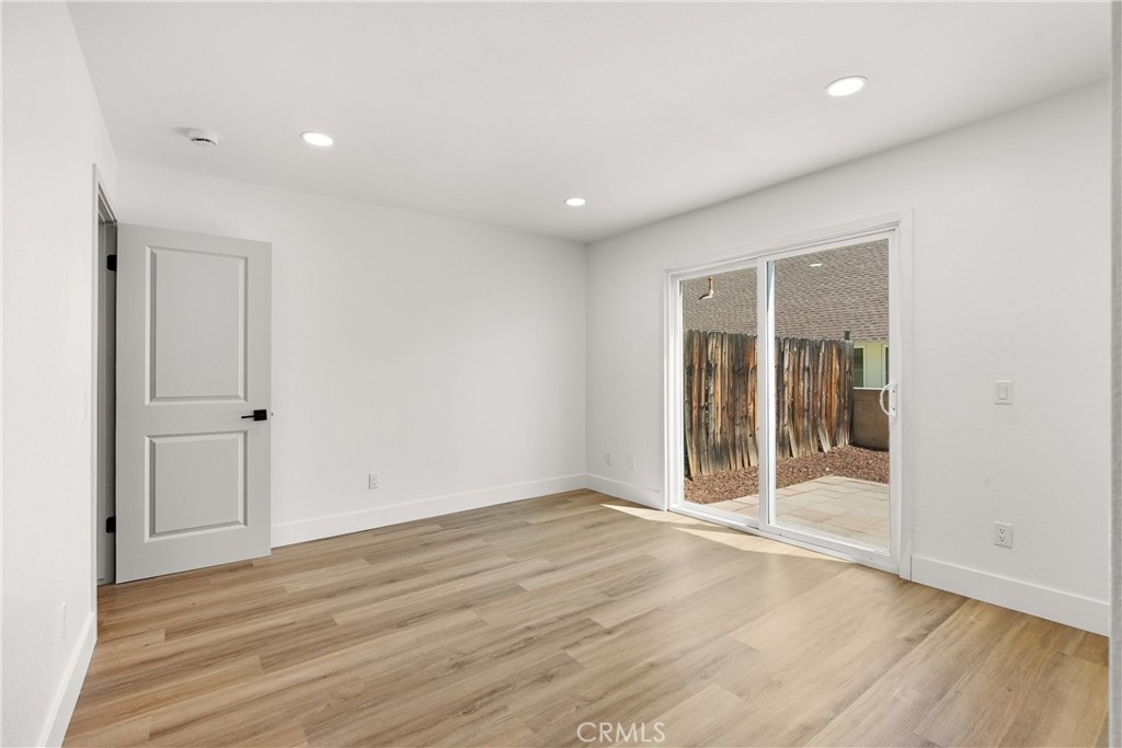 87 Tennessee Street, Unit C Redlands, CA 92373 - Photo 25 of 32 an empty room with wooden floor and door