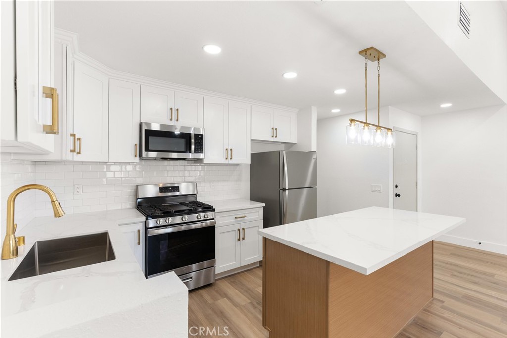 87 Tennessee Street, Unit C Redlands, CA 92373 - Photo 9 of 32 a kitchen with kitchen island a sink a stove a refrigerator and cabinets