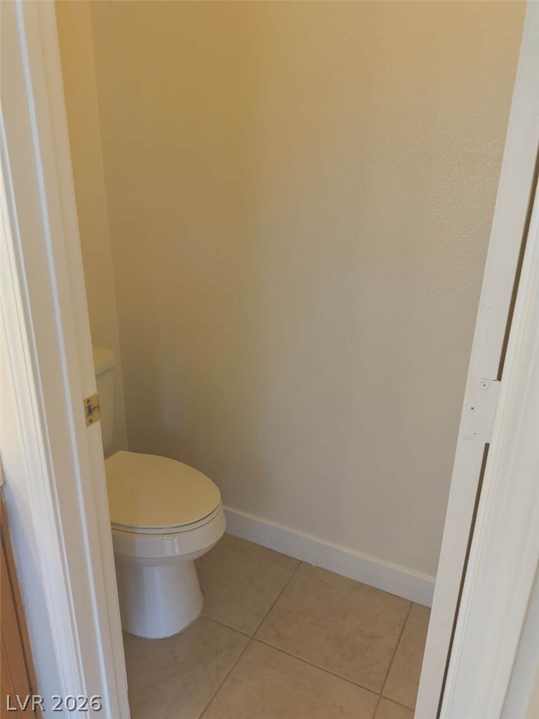 9725 Pima Point Avenue Las Vegas, NV 89147 - Photo 19 of 35 A well-maintained toilet with neutral-toned tiled flooring awaits.