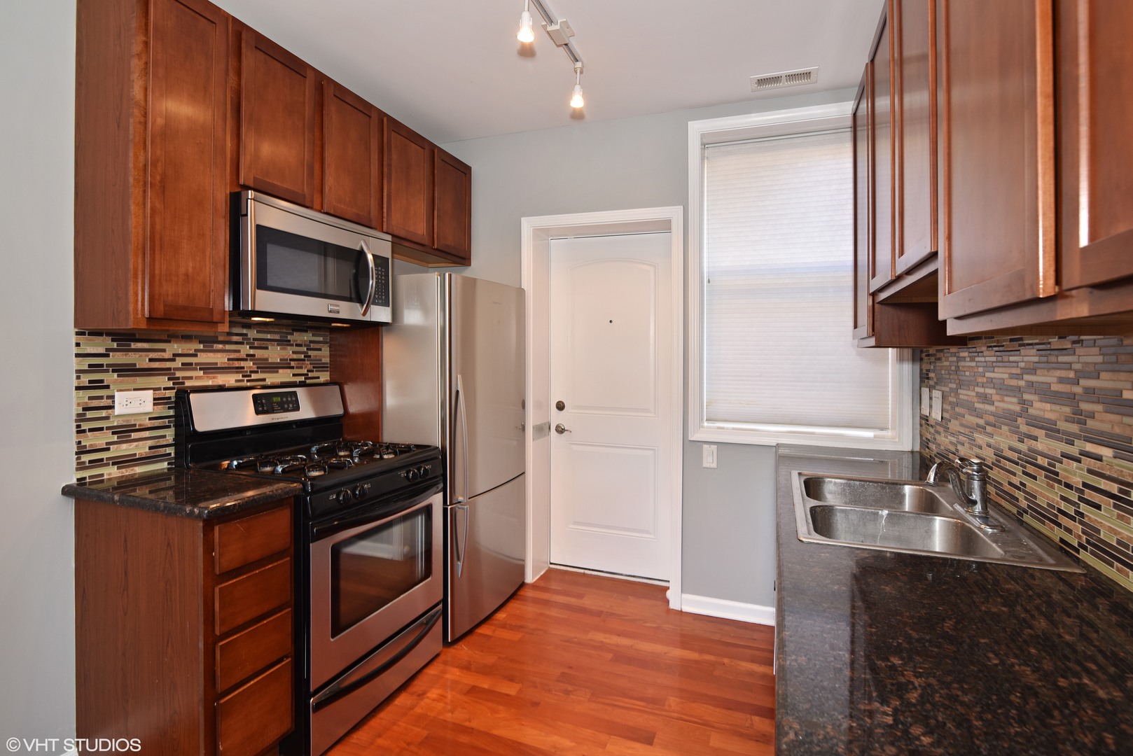 1750 West Rascher Avenue, Unit 2 Chicago, IL 60640 - Photo 4 of 12 a kitchen with stainless steel appliances granite countertop a stove microwave and refrigerator