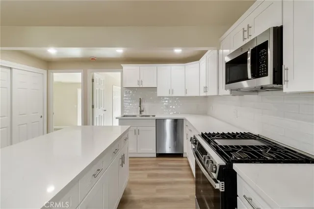 a kitchen with stainless steel appliances kitchen island sink stove and cabinets