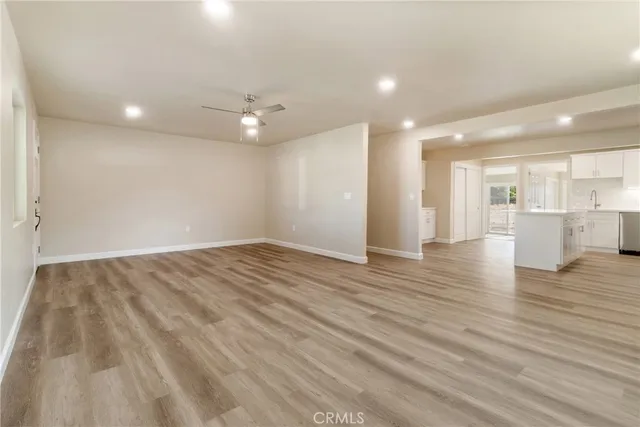wooden floor in an empty room with a kitchen