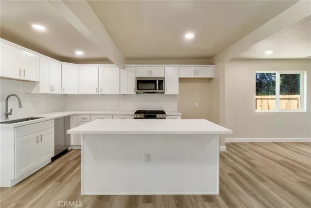 a kitchen with kitchen island sink stove and white cabinets
