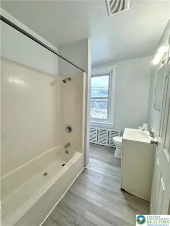 a bathroom with a tub shower and sink