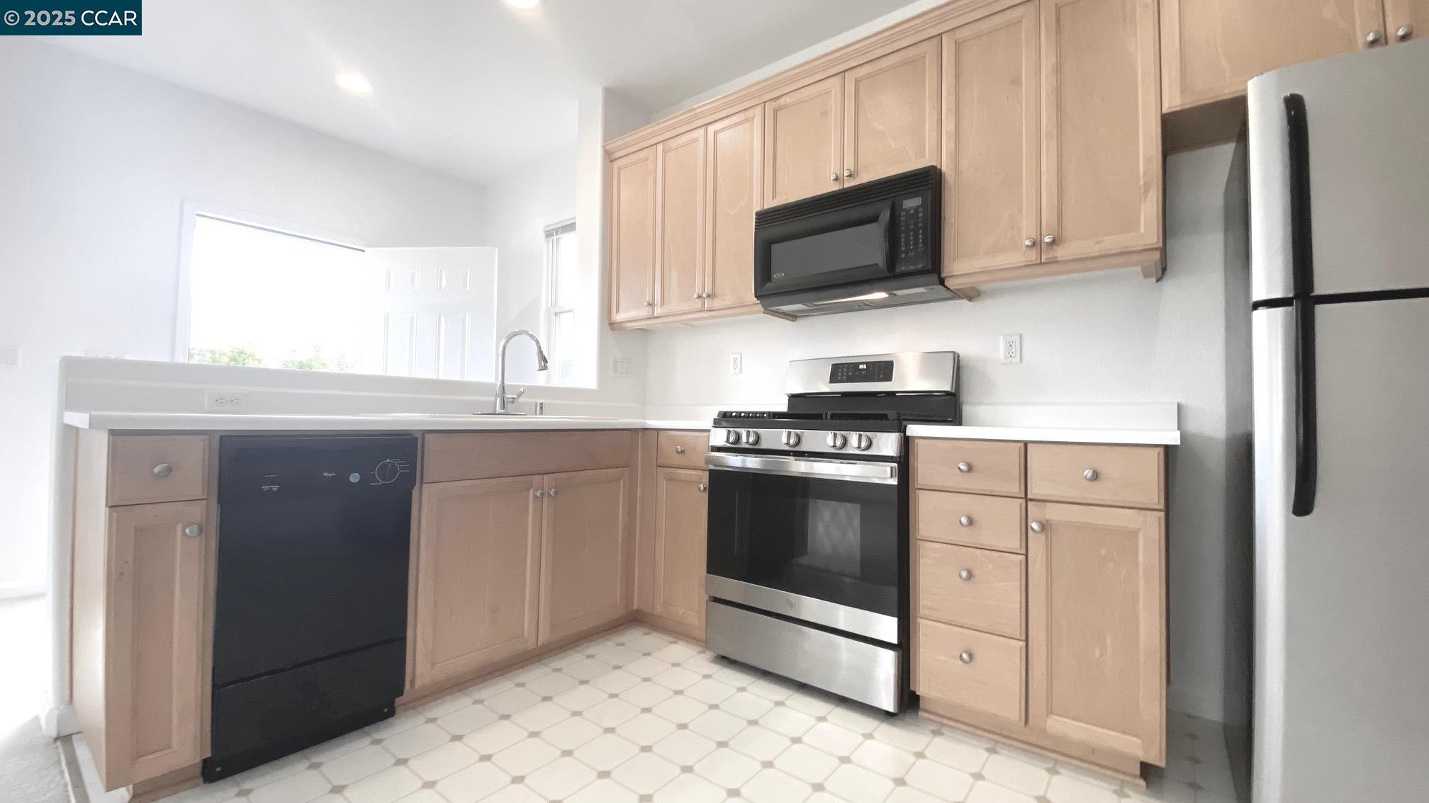 1027 Main Street, Unit B Hercules, CA 94547 - Photo 15 of 39 a kitchen with stainless steel appliances a stove a sink and a microwave