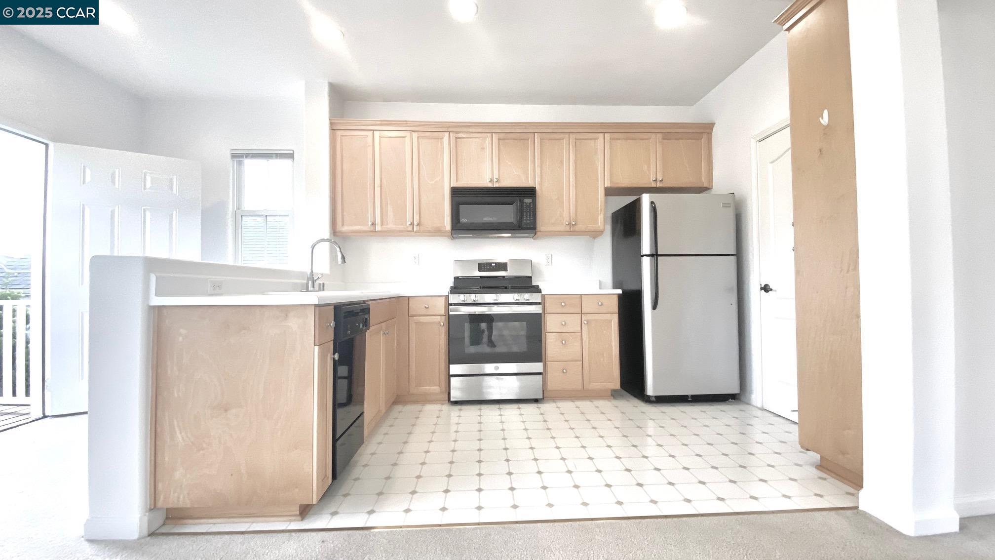 1027 Main Street, Unit B Hercules, CA 94547 - Photo 18 of 39 a kitchen with stainless steel appliances a refrigerator and a stove top oven