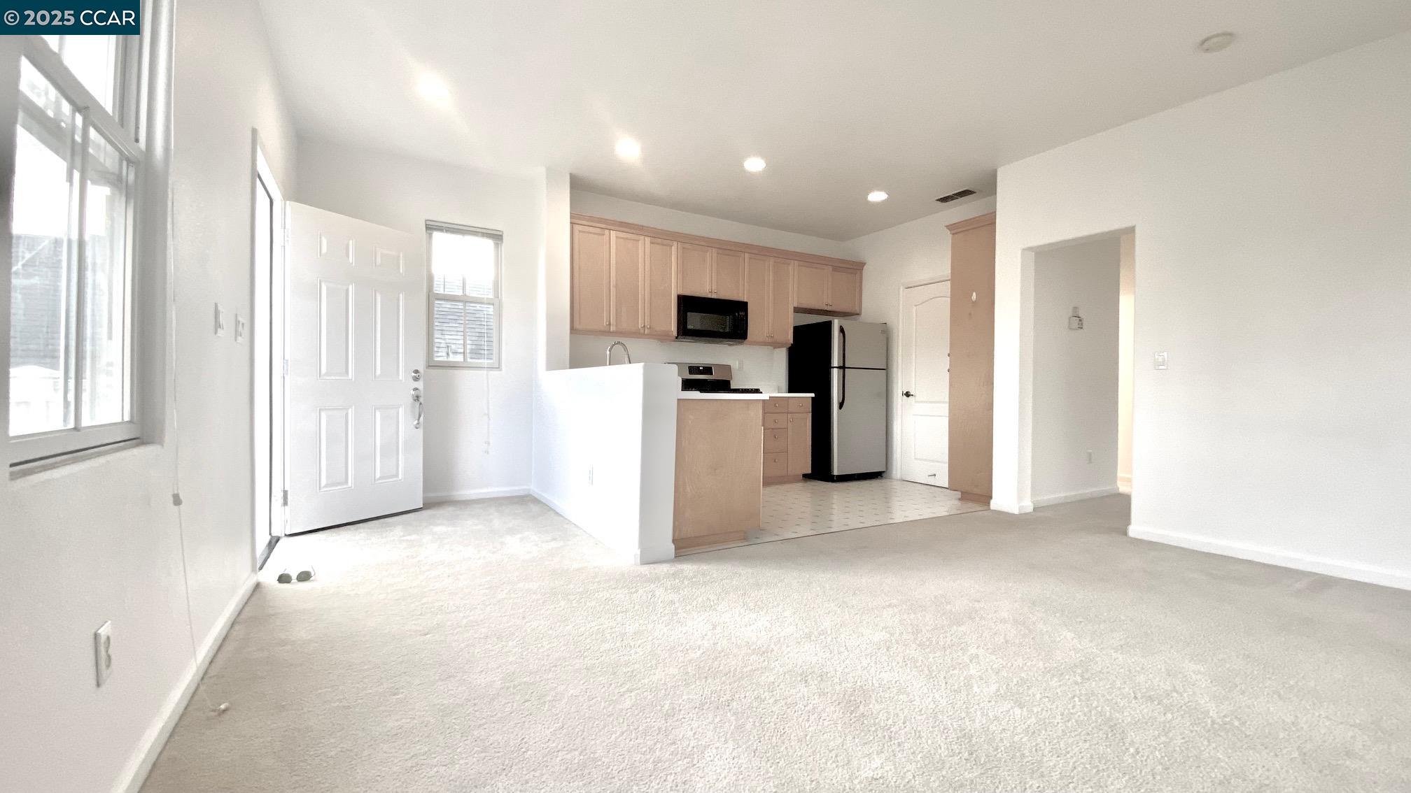 1027 Main Street, Unit B Hercules, CA 94547 - Photo 19 of 39 a view of a kitchen with a refrigerator a microwave and a sink