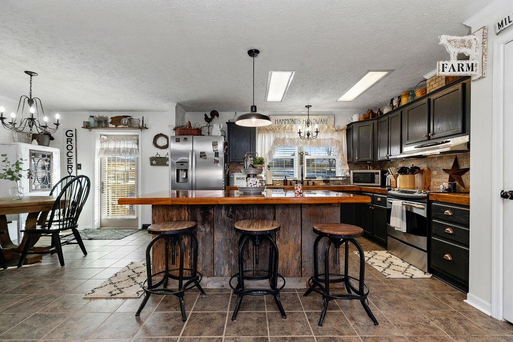 264 Steeles Fort Road Raphine, VA 24472 - Photo 20 of 50 a kitchen with stainless steel appliances kitchen island granite countertop a table chairs sink and cabinets