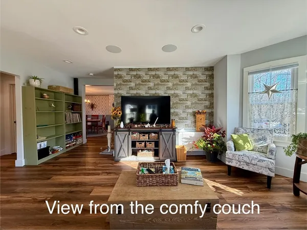 a view of a big room with wooden floor and windows