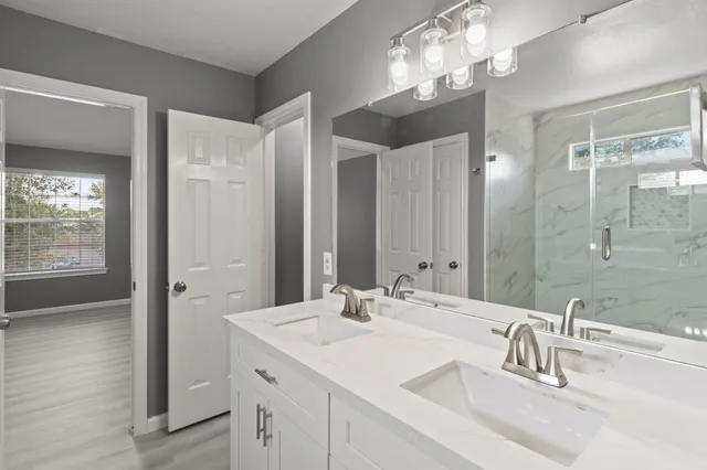 a bathroom with double vanity sink and a mirror