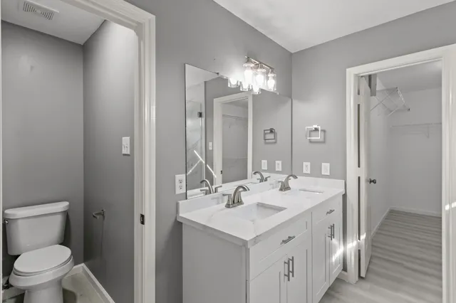 a spacious bathroom with a double vanity sink toilet and shower