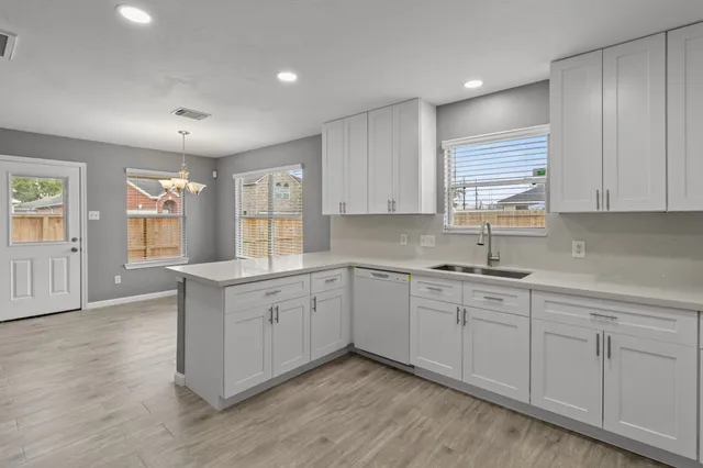 a kitchen with sink cabinets and wooden floor