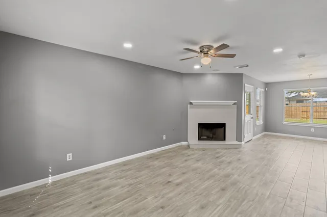 an empty room with a fireplace and fan