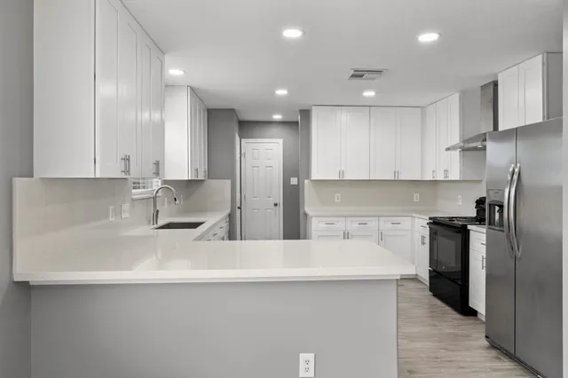 a kitchen with stainless steel appliances a sink stove and refrigerator