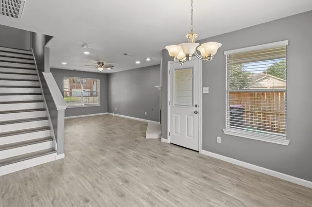 a view of a livingroom with wooden floor and windows