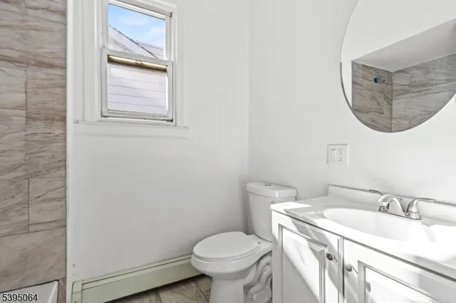 a bathroom with a granite countertop toilet sink and mirror