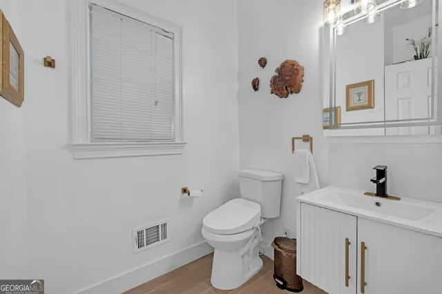 a bathroom with a toilet a sink and mirror