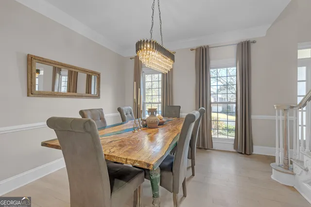 a dining room with furniture a chandelier and window