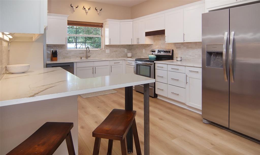 105 Turnberry Loop Graford, TX 76449 - Photo 8 of 34 a kitchen with stainless steel appliances a sink a stove a refrigerator and cabinets