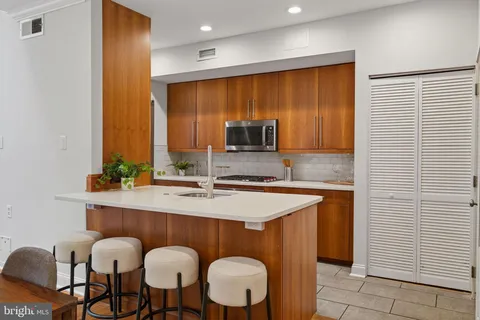 a kitchen with stainless steel appliances granite countertop wooden cabinets a stove a sink and a microwave
