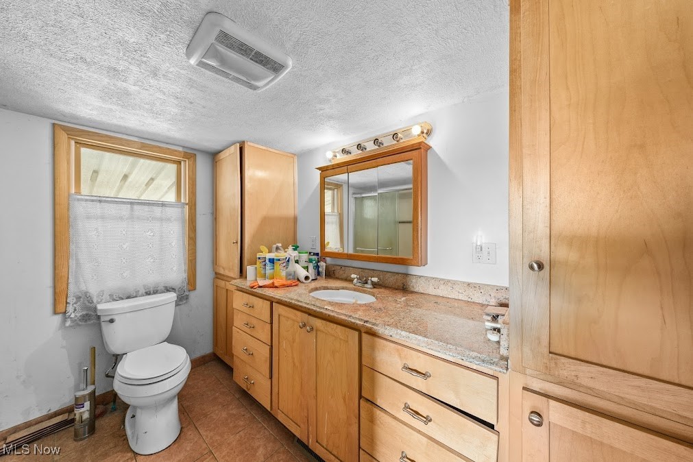 5324 Streeter Road Mantua, OH 44255 - Photo 4 of 37 Bathroom featuring vanity, tile patterned flooring, toilet, and a textured ceiling