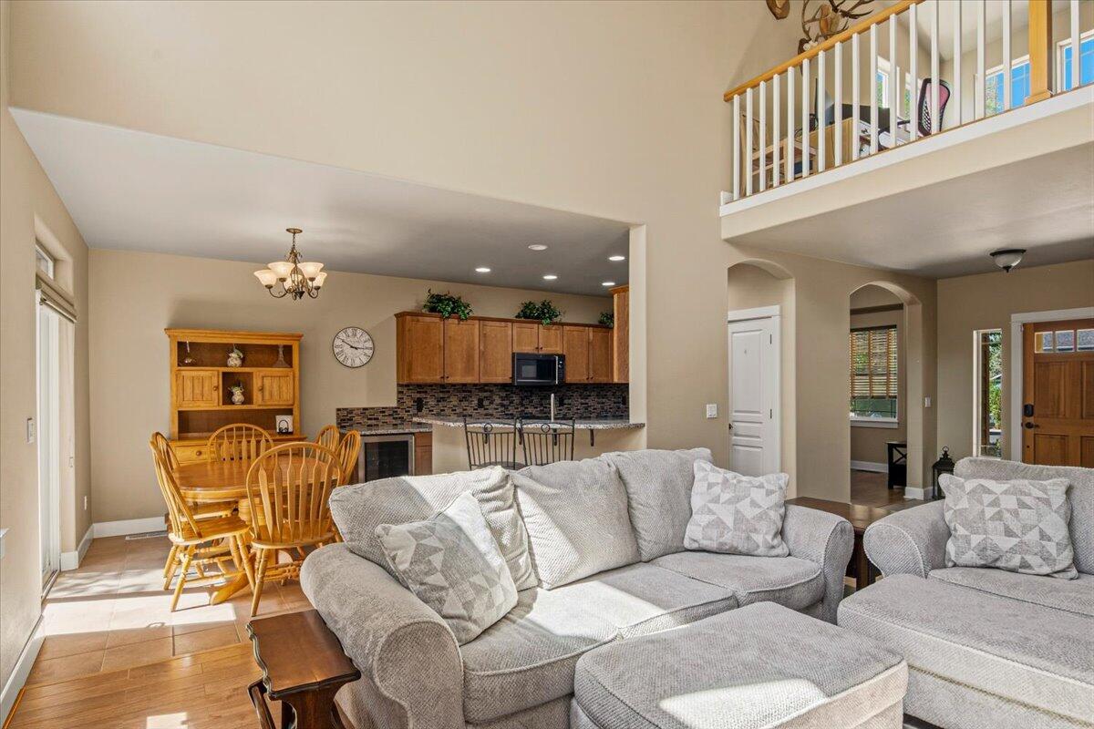 1339 Southwest Rimrock Way Redmond, OR 97756 - Photo 4 of 26 a living room with furniture and a dining table with wooden floor