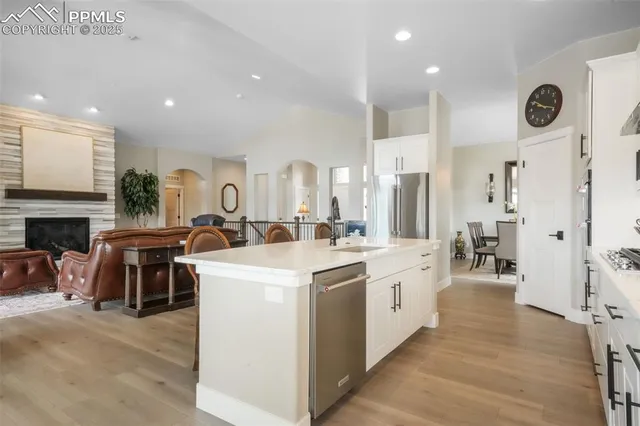 a large white kitchen with a large window and stainless steel appliances