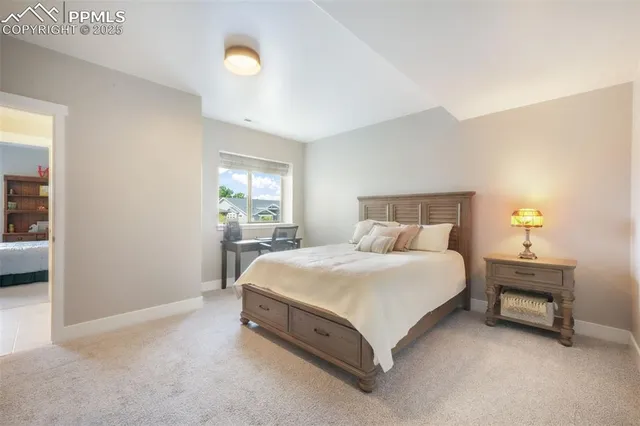 a bed sitting in a bedroom next to a lamp