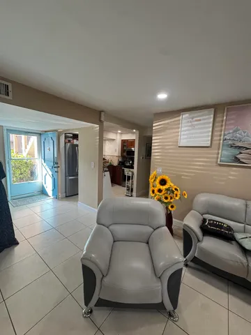 a living room with furniture flowers and a flat screen tv