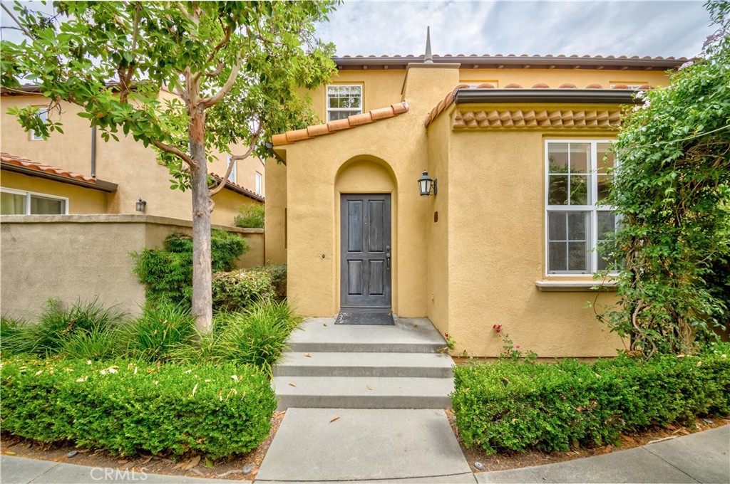 a front view of a house with plants and trees