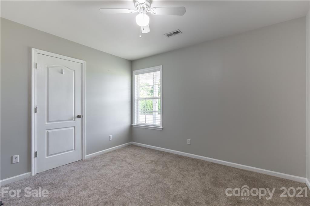 5150 Taxahaw Road Lancaster, SC 29720 - Photo 17 of 27 an empty room with a chandelier fan and windows