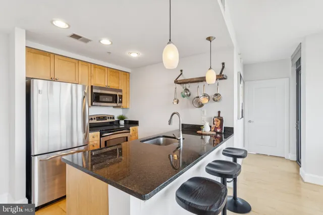a kitchen with stainless steel appliances granite countertop a sink a stove and a refrigerator