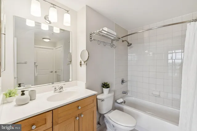 a bathroom with a double vanity sink toilet mirror and shower