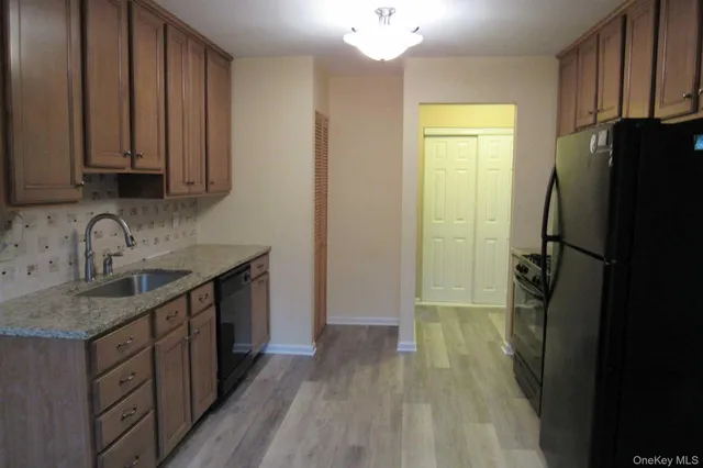 a kitchen with a sink a refrigerator and cabinets