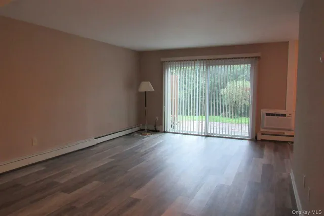 a view of a room with wooden floor and a window