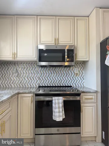 a kitchen with granite countertop white cabinets and black stove top oven