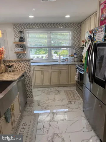 a kitchen with stainless steel appliances granite countertop a sink stove and cabinets