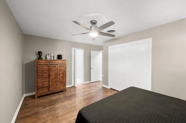 a bedroom with bed and wooden floor