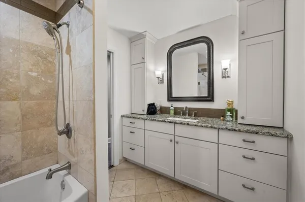 a spacious bathroom with a granite countertop sink mirror and shower